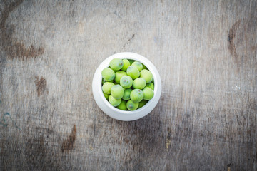 Fresh lotus seeds in vase and on wooden table background.