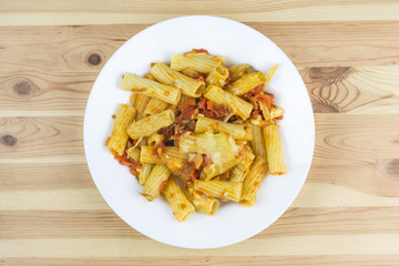 Pasta with cheese and sauce in plate on wood table