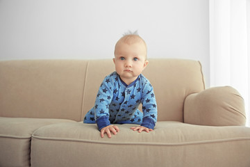 Adorable little baby crawling on sofa