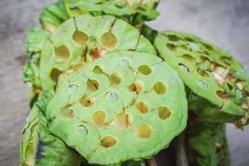 Fresh lotus seeds, green pod on wooden table background.