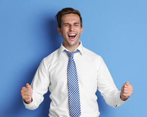 Young happy businessman on blue background