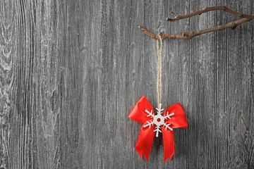 Christmas decor hanging on branch against grey wooden background