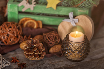 Fototapeta na wymiar Composition of candle and natural decor on wooden background, close up view