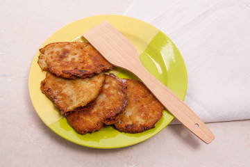 Potato pancakes with meat on green plate in Belarusian style on