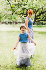 Fototapeta premium beautiful mother and daughter standing in the green garden
