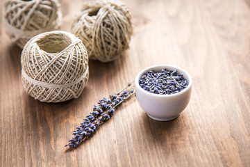 lavender flowers with spool of thread on a wooden background © yuliasverdlova