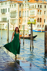 Wind blows woman's dress while she walks along the canal in Veni