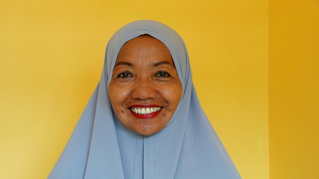 l&auml;chelnde Indonesierin mit Kopftuch