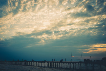 Obraz premium Filed wooden bridge into silhouette in the sea against sunrise sunset