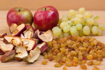 Raisins and dried apples on a wooden table.