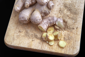 Close up of different forms of ginger against a wood worktop
