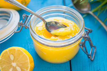Lemon Curd in Jar on Blue Wooden Background