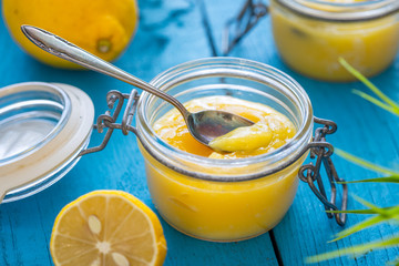 Lemon Curd in Jar on Blue Wooden Background, Close-up