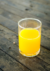 orange juice in glass on wooden background