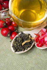 Tea with rosehip on a table. Useful drink for health. Herbal tea petals of Pelargonium and rowan. Traditional medicine. 