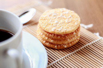 Crispy Rice Crackers with Hot cup of coffee on wooden table back