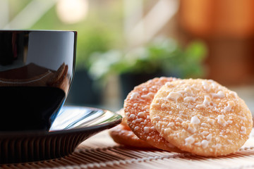 Crispy Rice Crackers with Hot cup of coffee on wooden table back
