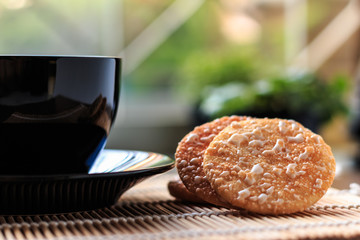 Crispy Rice Crackers with Hot cup of coffee on wooden table back