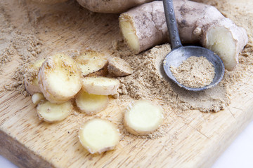 Close up of different forms of ginger against a wood worktop