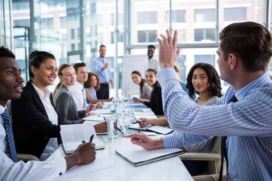 Colleague raising his hand during meeting