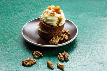carrot cake with walnuts, prunes and dried apricots on a green wood background. tinting. selective focus