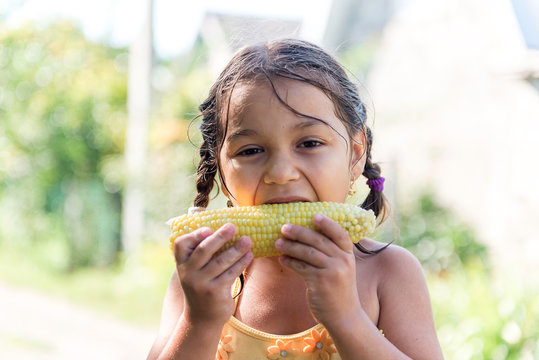 Child In The Garden - Lovely Girl Eating Corn On The Cob (GMO Free)