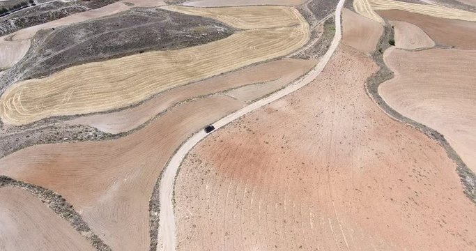 Coche por camino entre campos labrados