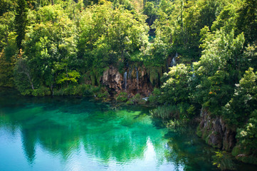 Waterfall and lake with transparent emerald water