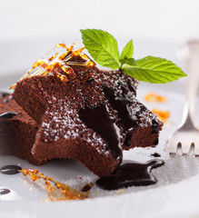 Homemade tasty delicious christmas dessert on a plate - brownie with caramel and chocolate sauce, selective focus