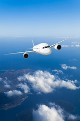 Podróż samolotem, samolot lecący w błękitnym niebie wysoko nad ziemią