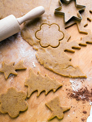 Cookies forms and gingerbread dough on wooden pastry board