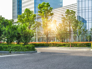 empty asphalt road by modern office building.