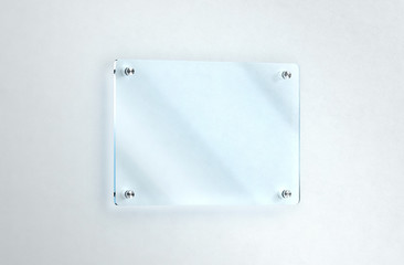 Blank glass nameplate mounted on the wall mockup, clipping path, 3d rendering. Clear acrylic sign frame design mock up. Empty shiny mirror holder fixed on white wall. Office door glassy signage.