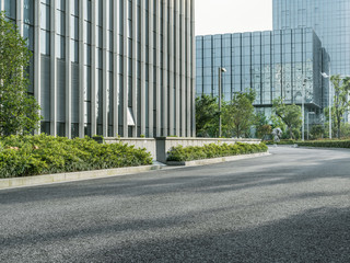 Fototapeta premium empty asphalt road by modern office building.