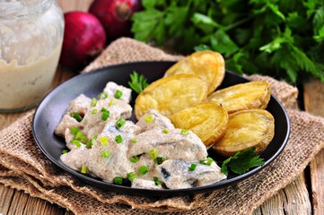 Salted herring marinated in white caviar sauce with baked potatoes.