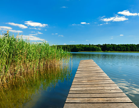 Wooden Pier on Lake under Blue Sky in Summer Landscape