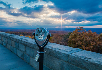 Binoculars point towards a majestic sunburst overlooking brilliant fall foliage at the top of New Jersey at High Point State Park © rabbitti