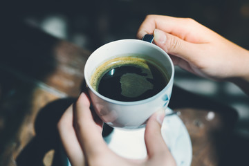 Female hands holding cup of coffee.