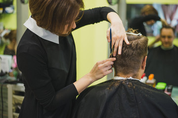 Professional barber styling hair of his client