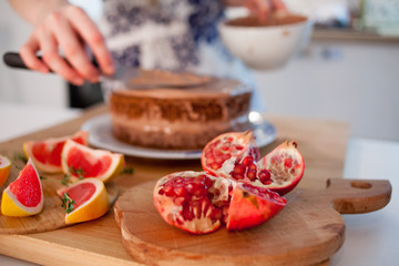 Two girls making a cake on the kitchen. Women's hands, causing the chocolate cream