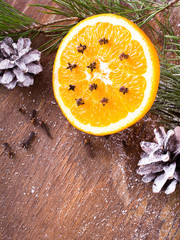 Christmas background with orange, cloves, stars and fir branches on wooden background