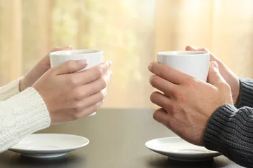 Zelfklevend Fotobehang Hands of couple with coffee cups © Antonioguillem