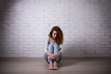 depression and loneliness - sad woman sitting on the floor over
