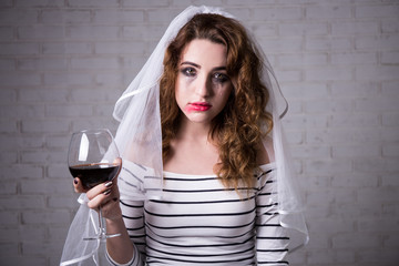 portrait of sad bride crying and drinking wine