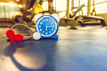 Time Clock on rubber floor blue color with blue fitness gym. Time and healthy take care you self Concept