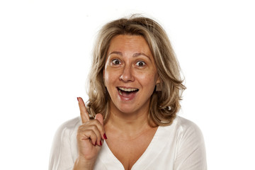 Portrait of happy beautiful middle-aged woman with an idea and finger up
