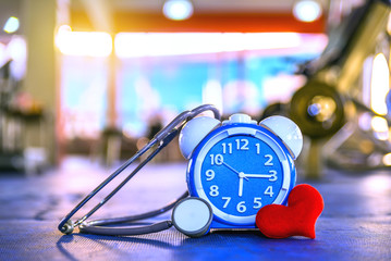 Time Clock on rubber floor blue color with blue fitness gym. Time and healthy take care you self Concept