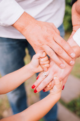People, charity, family and care concept - close up of woman hands holding girl hands
