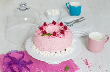 gugelhupf mit rosa buttercreme und Himbeeren