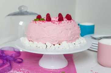 gugelhupf mit rosa buttercreme und Himbeeren